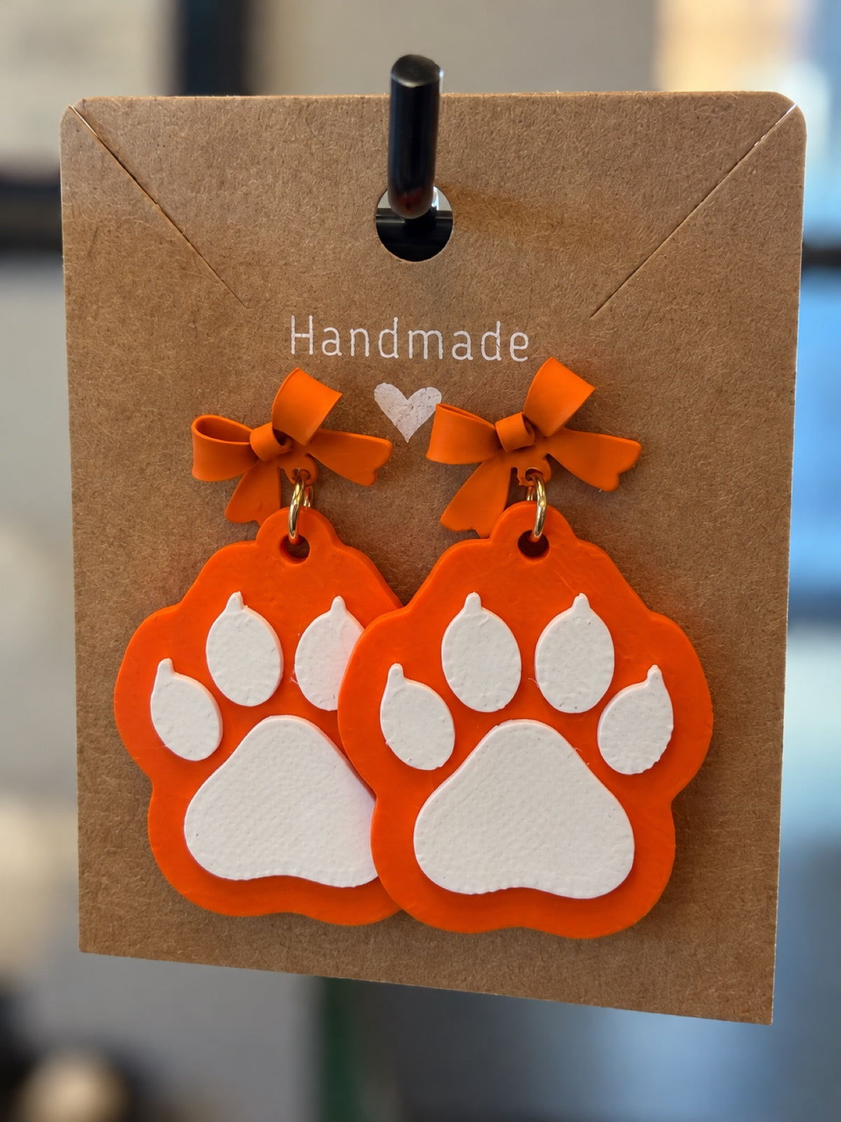 3D printed orange and white paw print dangle earrings with bow tops - Celina Bobcats spirit jewelry