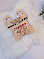 Close-up of engraved wooden teacher gift tag with beaded teacher bracelet on white blanket