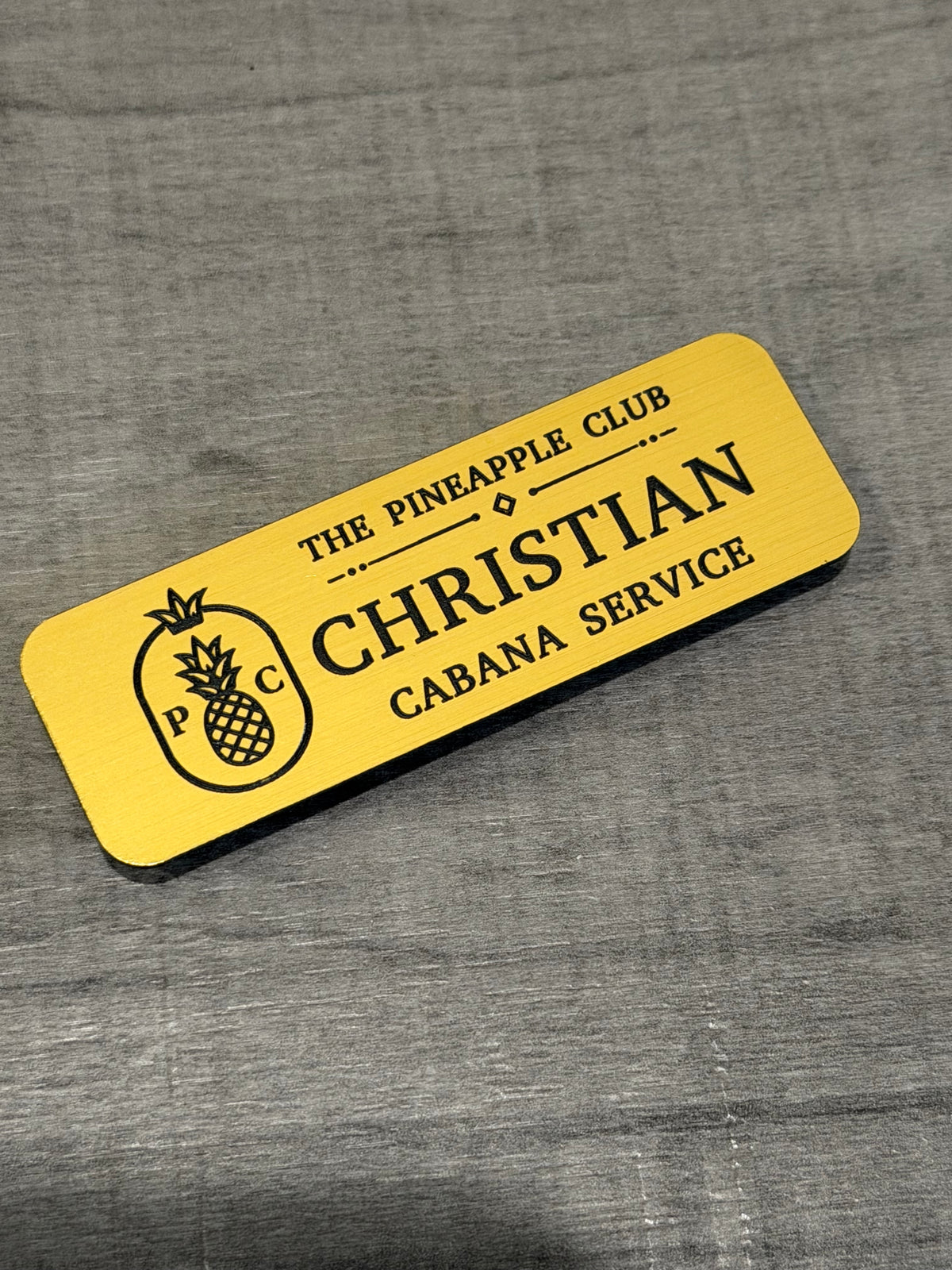 Yellow engraved name badge with pineapple logo: Christian, Cabana Service