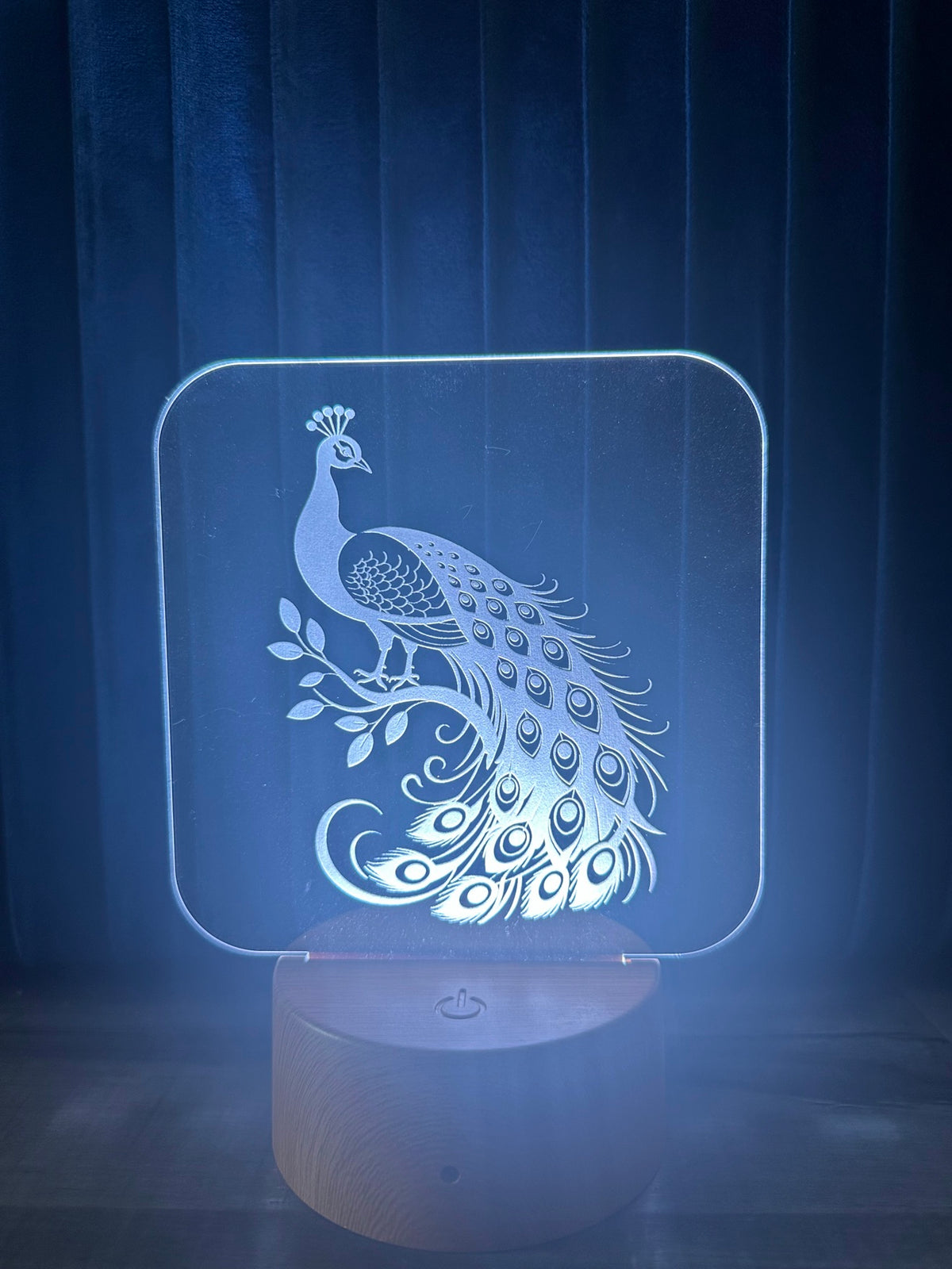 Peacock 3D LED night light glowing blue - laser engraved acrylic lamp with peacock on branch, wooden base