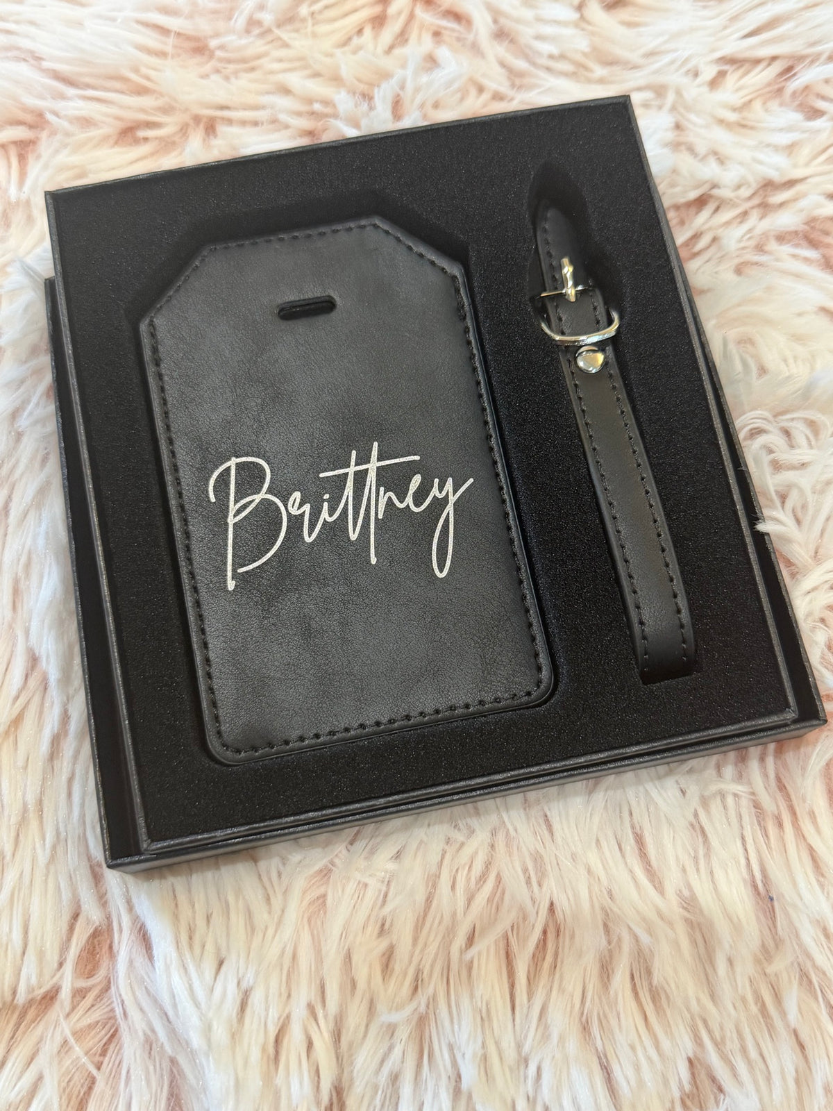 Black leatherette luggage tag engraved with the name Brittney in script font